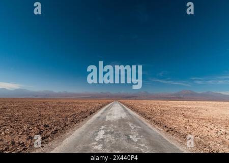 Eine leere Straße durch eine Salzpflahle im Salar de Atacama. Salar de Atacama, Atacama-Wüste, Region Antofagasta, Chile. Stockfoto