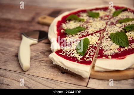 Eine Scheibe Vanilleeis-Pizza mit Erdbeersauce und Pfefferminz und weißer Schokolade Stockfoto