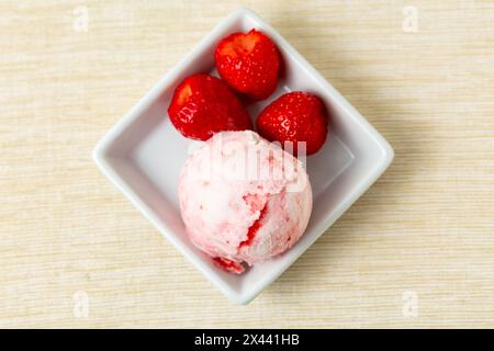 Hausgemachte Schaufel Joghurt-Erdbeereis mit frischen Erdbeeren von oben Stockfoto
