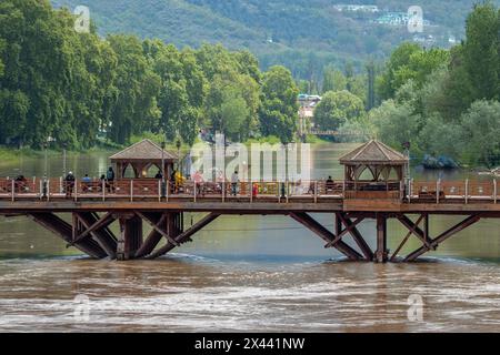 Srinagar, Indien. April 2024 30. Man sieht Menschen, die über eine Brücke laufen, während der Wasserstand im Jhelum am Dienstagmorgen die „Hochwasserdeklaration“-Markierung in Srinagar überquerte. In Jammu und Kaschmir wird erwartet, dass sich das Wetter ab morgen verbessern wird, wobei die örtliche Wetterabteilung bis zum 5. Mai allgemein bewölkte Bedingungen vorhersagt. (Foto: Faisal Bashir/SOPA Images/SIPA USA) Credit: SIPA USA/Alamy Live News Stockfoto