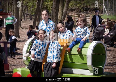 Eine chassidische jüdische Familie mit Kindern, die identische Oberteile tragen, posieren für ein Foto während des Pessach. Auf einer Farm im Rockland County. Stockfoto