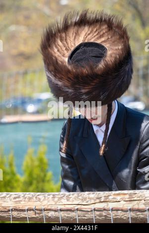 Ein orthodoxer jüdischer Mann mit langem gelocktem Peyus, der einen Shteimel-Pelzhut trägt. Es wird an Sabbath, Feiertagen und einigen besonderen persönlichen Feierlichkeiten getragen. Stockfoto