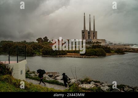 Die Schornsteine des ehemaligen Thermalkraftwerks Sant Adria del Besos erheben sich vor dem Strand Litoral und der Mündung des Flusses Besos bei Regen und Sturm Stockfoto