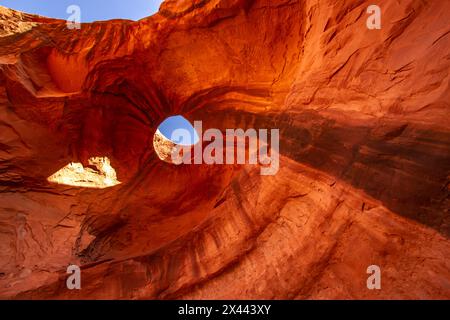 USA, Arizona, Monument Valley Navajo Tribal Park. Großer Hogan Arch und Loch in Stein. Stockfoto