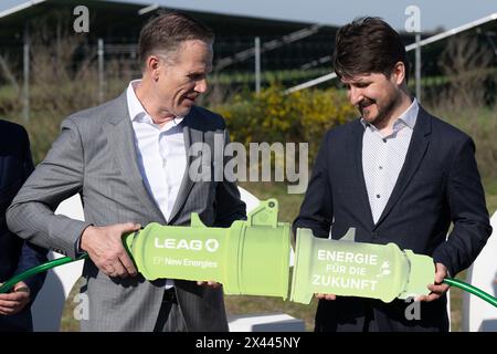 30. April 2024, Sachsen, Boxberg: Thorsten Kramer (links), CEO von Leag, und Dominique Guillou, Geschäftsführer von EP New Energies, halten bei der Eröffnung einer bodenmontierten Photovoltaikanlage (PV-Park) vor dem Kraftwerk Boxberg einen symbolischen Netzstecker. Der Park ist Teil der Leag Gigawatt Factory. Foto: Sebastian Kahnert/dpa Stockfoto