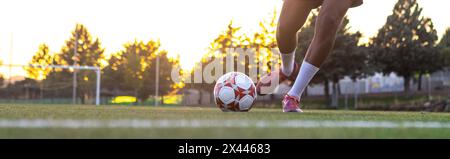 Spieler Füße mit dem Ball, der ein Tor erzielt. Fußballspieler auf dem Spielfeld, der mit dem Ball läuft. Fußballspieler Füße laufen mit dem Ball vor Stockfoto