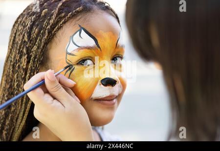 Kleines Mädchen ihr Gesicht durch Kinderschminken Künstler gemalt. Stockfoto