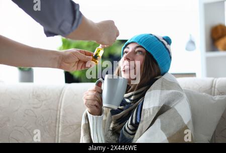 Mann fügt Marihuana Öl auf kranke Frau in Tee Extrakt. Stockfoto