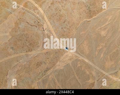 Aus der Luft, weite, leere Landschaft, Straßen- und Geländewagen, Ansicht von oben nach unten, zwei Wege teilen sich, symbolisch für Entscheidungen, Moldo Too Mountains, Naryn Stockfoto