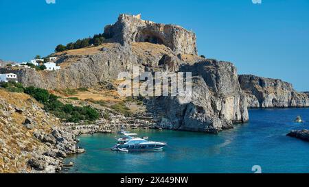 Mittelalterliche Burg über einer Stadt an der Küste mit Booten im Wasser, Paulus Bucht, unterhalb der Akropolis von Lindos, Lindos, Rhodos, Dodekanes, Griechisch Stockfoto