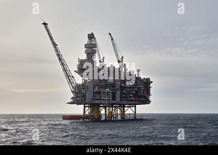 Nahaufnahme der Offshore-Plattform für Öl und Gas mit Versorgungsschiff, das Frachtaktivitäten im Meer durchführt. Stockfoto