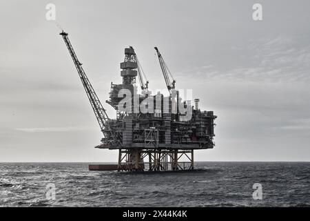 Nahaufnahme der Offshore-Plattform für Öl und Gas mit Versorgungsschiff, das Frachtaktivitäten im Meer durchführt. Stockfoto
