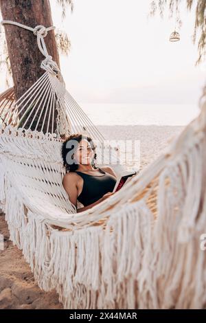 Porträt einer lächelnden Reifen Frau, die in einer Hängematte am Strand liegt Stockfoto