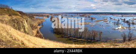 Frühlingslandschaft, Panorama, Banner - Flut im Flusstal der Siverskyi (Seversky) Donets, der gewundene Fluss über den Wiesen zwischen Hügeln und Fo Stockfoto