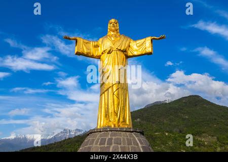 Aus der Vogelperspektive die goldene Statue des Kolosses von Cristo Re. Bienno, Provinz Brescia, Valcamonica-Tal, Lombardei, Italien, Europa. Stockfoto