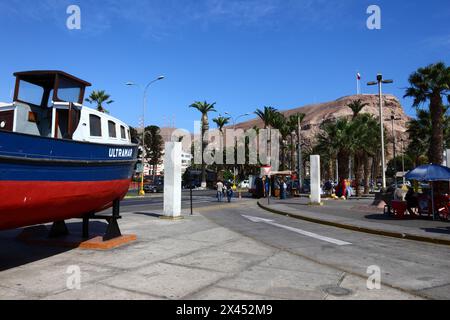 Fischerboot auf der Av Maximo Lira neben dem Eingang zum/Ausgang vom Hafen, El Morro Landzunge im Hintergrund, Arica, Chile Stockfoto