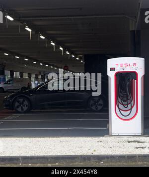 Brest, Frankreich - 7. April 2024: Eine statische Aufnahme eines soliden schwarzen Tesla Model 3 Doppelmotors beim Brest V3 Superchager an einem regnerischen Frühlingstag. Wählen Sie Aus Stockfoto