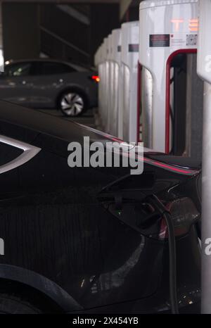 Brest, Frankreich - 7. April 2024: Eine statische Aufnahme eines soliden schwarzen Tesla Model 3 Doppelmotors beim Brest V3 Superchager an einem regnerischen Frühlingstag. Wählen Sie Aus Stockfoto