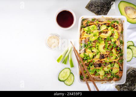 Philadelphia Sushi Bake Rezept Auflauf mit Reis, Frischkäse, Lachsforelle, Algen, Avocado, Soße, grüne Zwiebeln. Serviert mit geröstetem Nori-Sch Stockfoto