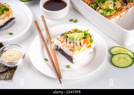 Philadelphia Sushi Bake Rezept Auflauf mit Reis, Frischkäse, Lachsforelle, Algen, Avocado, Soße, grüne Zwiebeln. Serviert mit geröstetem Nori-Sch Stockfoto