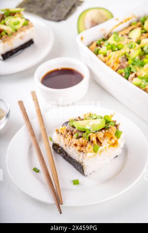 Philadelphia Sushi Bake Rezept Auflauf mit Reis, Frischkäse, Lachsforelle, Algen, Avocado, Soße, grüne Zwiebeln. Serviert mit geröstetem Nori-Sch Stockfoto