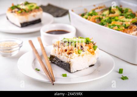 Philadelphia Sushi Bake Rezept Auflauf mit Reis, Frischkäse, Lachsforelle, Algen, Avocado, Soße, grüne Zwiebeln. Serviert mit geröstetem Nori-Sch Stockfoto