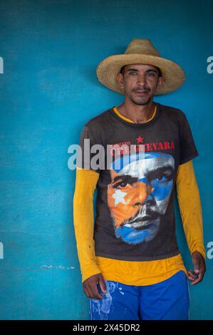 Ein junger Mann mit Sombrero und Che Guevara T-Shirt stand an der blauen Wand eines Bauernhauses im Vinales Valley, Vinales, Kuba. Stockfoto