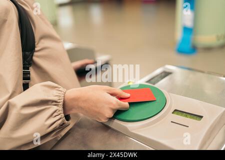 Junge Frau, die das Ticket für die U-Bahn benutzt Stockfoto