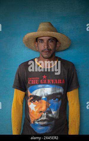 Ein junger Mann mit Sombrero und Che Guevara T-Shirt stand an der blauen Wand eines Bauernhauses im Vinales Valley, Vinales, Kuba. Stockfoto