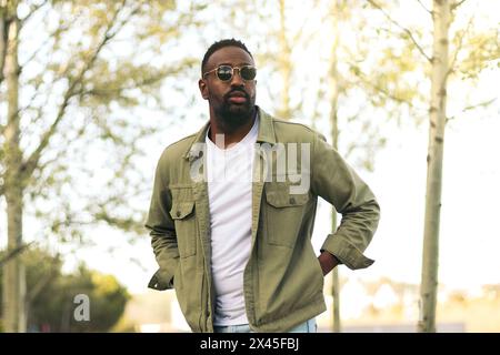 Attraktiver afro amerikanischer junger Mann mit Sonnenbrille, der in einem parken Stockfoto