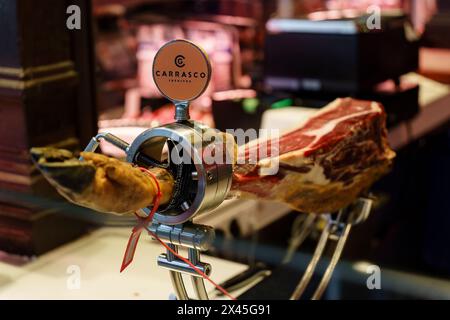 Madrid, Spanien. 11. Februar 2024: Leg of Dry-cured iberian Schinken (Jamon), im mercado de san miguel Stockfoto