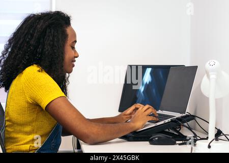 Moderne Produktivität: Afroamerikanerin, die zu Hause ferngesteuert am Laptop arbeitet Stockfoto
