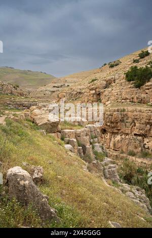 Eine Landschaft aus Klippen und Höhlen am Ufer des Prat-Baches in den Judäa-Wüstenhügeln in Israel. Stockfoto