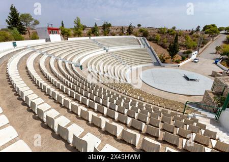 Öffentliches Freilufttheater mit perfekter halbrunder Form und vielen Reihen weißer Plastikstühle auf der Insel Salamina, Griechenland. Stockfoto