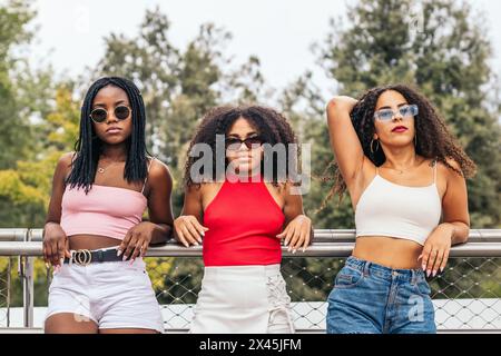 Drei junge afroamerikanische Frauen mit Afro-Haaren, die selbstbewusst in die Kamera schauen Stockfoto