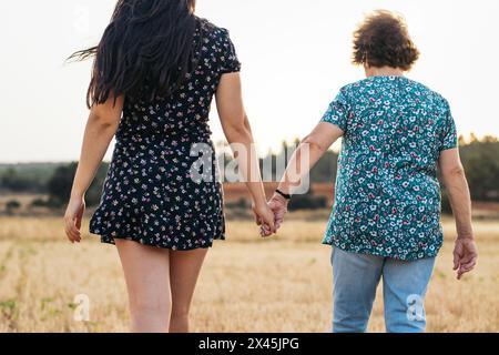Schöne Nahaufnahme auf eine alte Frau, die die Hände ihrer Enkelin hält. Nahaufnahme einer zerknitterten Hand und der Hände eines Jungen. Stockfoto