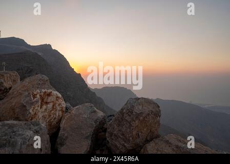 Die goldene Sonne strahlt hinter den strukturierten Felsbrocken Stockfoto