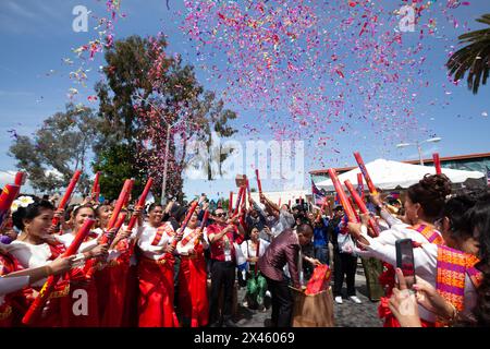 Frauen in traditioneller rot-weißer Kleidung aus dem Stop the Hate Program schießen bei der Cambodian New Year Parade and Festival 2 konfetting in die Luft Stockfoto