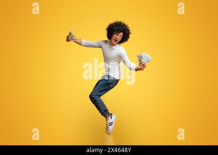 Happy african american Kerl tanzen auf Zehenspitzen mit Geld fans Stockfoto