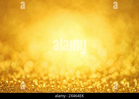 Goldener glitzernder Hintergrund. Glitzer-Textur mit dem Bokeh und den Lichtern, glänzende Metallgoldfolie funkeln Stockfoto