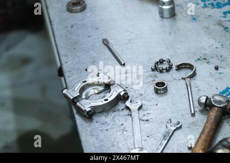 Von oben an das Werkzeug zum Entfernen des Kurbelwellenlagers aus Metall angebracht werkbank mit Schraubenschlüssel und Hammer in der Garage Stockfoto