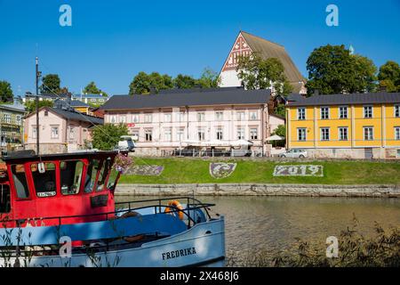 Porvoo, Finnland - 2. September: Stadtbild der Altstadt von Porvoo. Malerische Holzhäuser an einem Flusshang. Mittelalterliche lutherische Kathedrale aus Stein auf einem Hügel. Warmer, sonniger Sommertag. Stockfoto