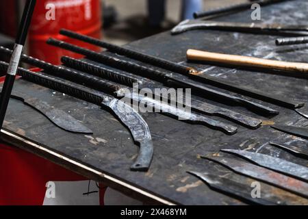 Reihen von verschiedenen Metallinstrumenten auf Tisch in Schmiede gelegt Stockfoto