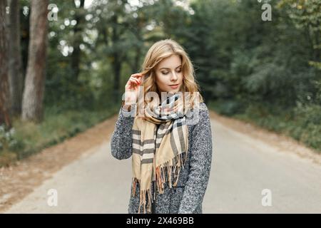 Stilvolles, schönes Mädchen in Herbstkleidung mit Einem Schal auf dem Hintergrund des Autumn Park Stockfoto