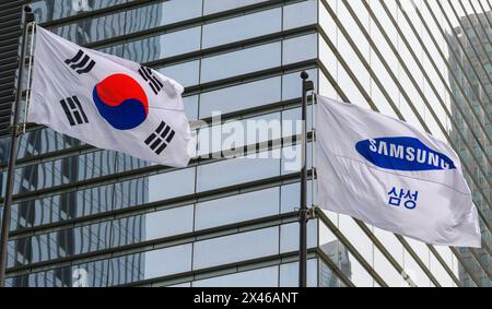 Eine südkoreanische Nationalflagge (L) mit der Flagge der Samsung Group (R) flattert vor dem Seocho-Gebäude des Unternehmens in Seoul. Samsung Electronics Co. Gab am 30. April bekannt, dass sein Betriebsergebnis im ersten Quartal mehr als verzehnfacht wurde, wobei das Chip-Geschäft zum ersten Mal seit fünf Quartalen auf Schwarz verlagert wurde. Samsung Electronics, der weltweit größte Hersteller von Smartphones und Speicherchips, sagte, dass sein Betriebsgewinn im Zeitraum Januar-März 4,8 Milliarden US-Dollar erreichte, verglichen mit 461.753.340 US-Dollar vor einem Jahr. Der Umsatz stieg um 12,8 Prozent auf 51.880.048.960 USD, und der Nettogewinn stieg in die Höhe Stockfoto