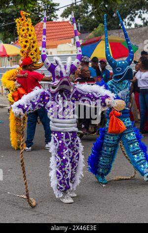 Ein Lechone-Kostüm aus Santiago mit Entenschnabelmaske und Hörnern bei der La Vega Karnevalsparade in der Dominikanischen Republik. Das erste dokumentierte Carni Stockfoto