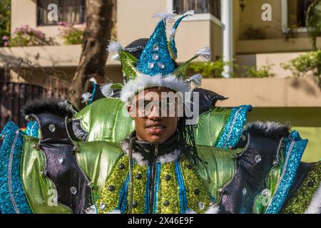 Junger Mann in einem ausgeklügelten Narrenkostüm marschiert bei der Karnevalsparade La Vega in der Dominikanischen Republik. Die erste dokumentierte Karnevalsfeier Stockfoto