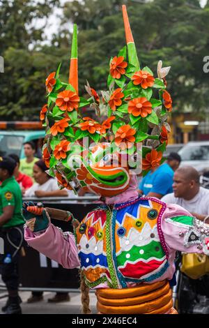 Ein Lechone-Kostüm aus Santiago mit Entenschnabelmaske und Hörnern bei der La Vega Karnevalsparade in der Dominikanischen Republik. Das erste dokumentierte Carni Stockfoto