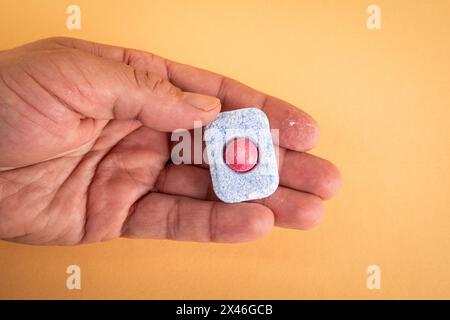 Geschirrspülkapsel in der Hand auf hellem Hintergrund. Stockfoto