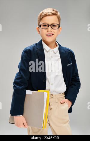 Junge in Brille mit Buch in der Hand, verströmt Intelligenz. Stockfoto